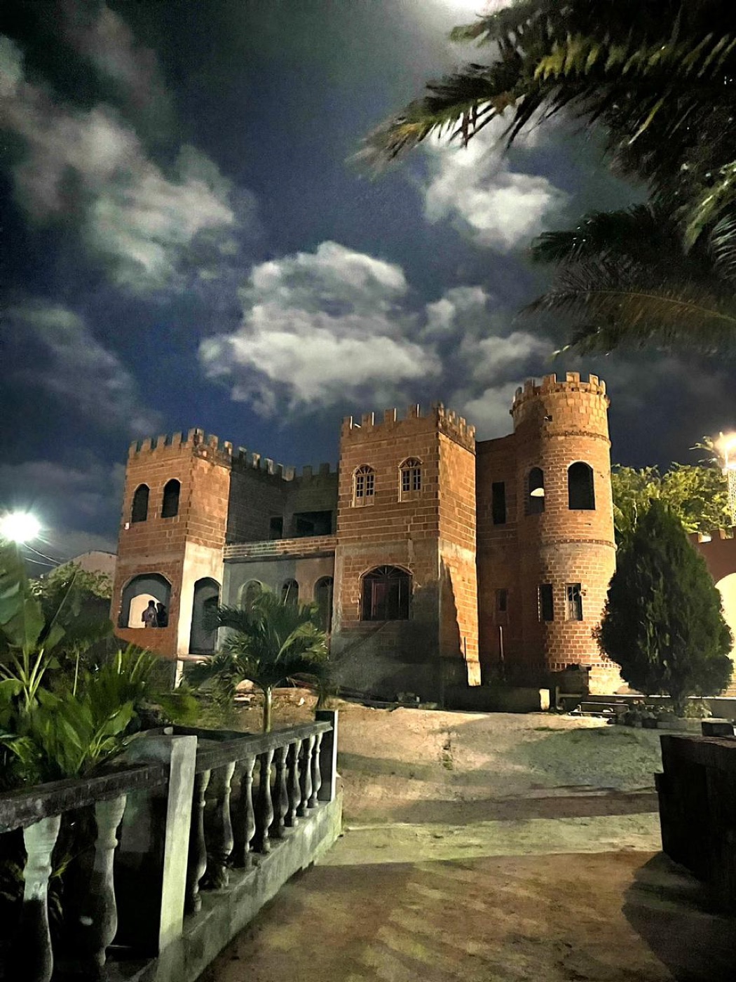 O Castelo do Rei Jadir à noite, com as torres de tijolo sob o céu nublado